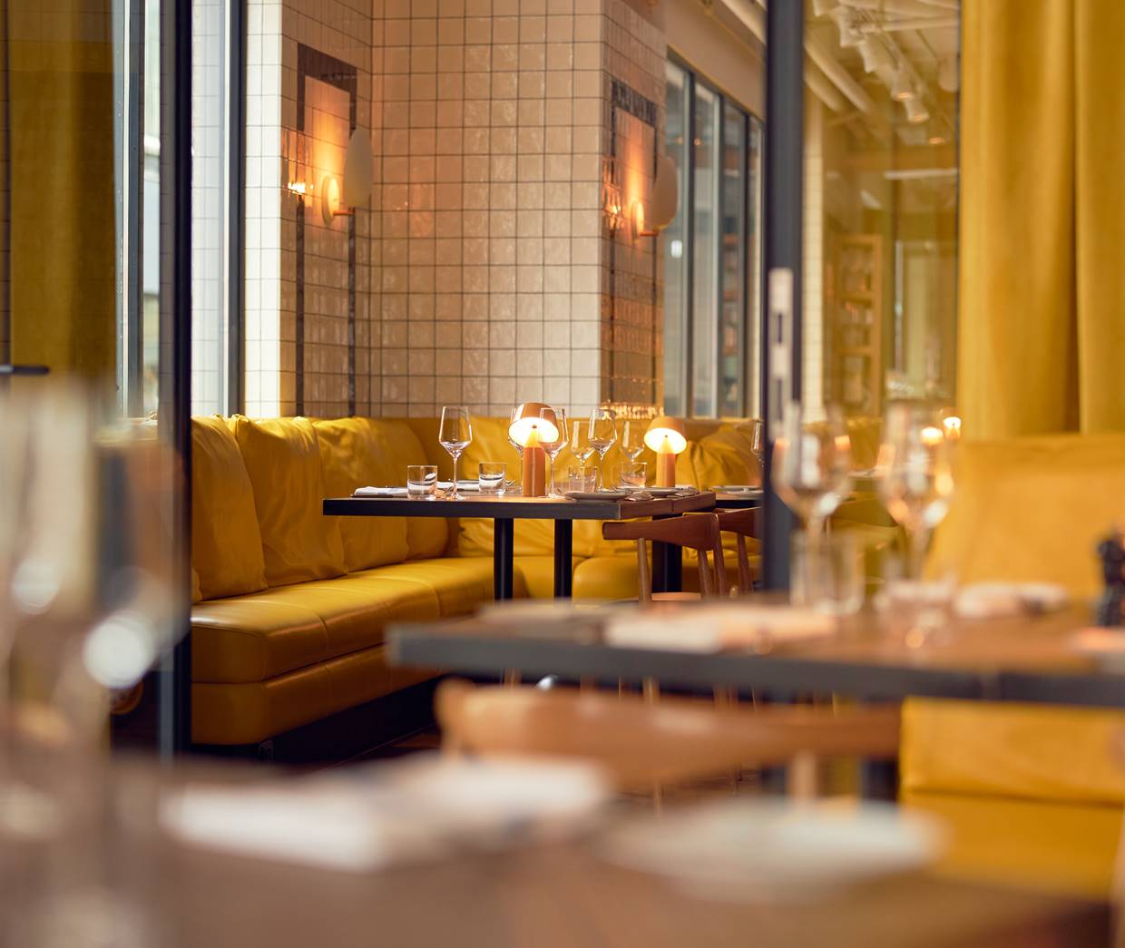 Intimate dining area with yellow seating, warm lighting, and a cosy ambiance, perfect for a private meal.