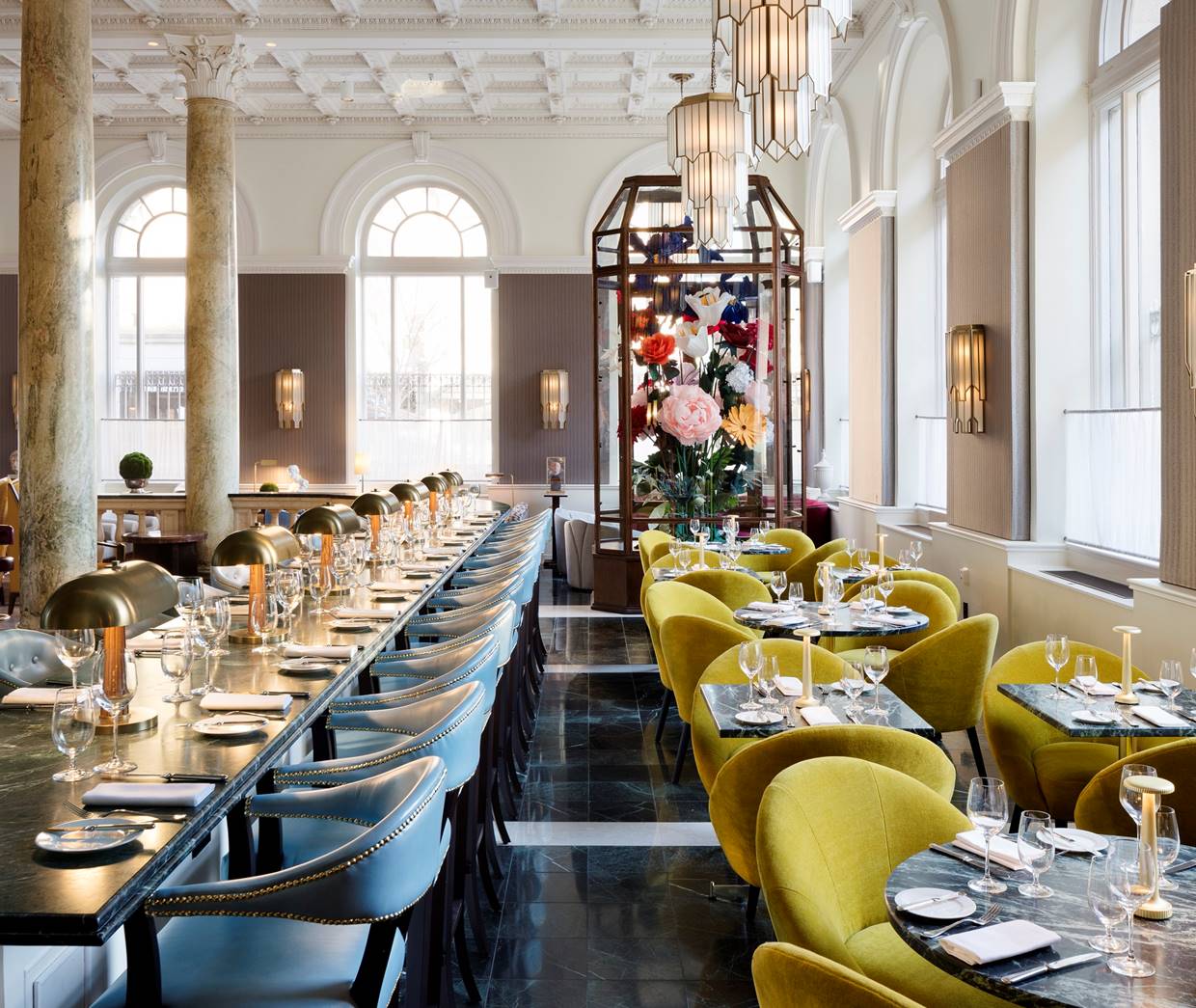Charming dining room with vintage-inspired decor, yellow and blue seating, and ambient lighting at Cafe Riggs in Washington.