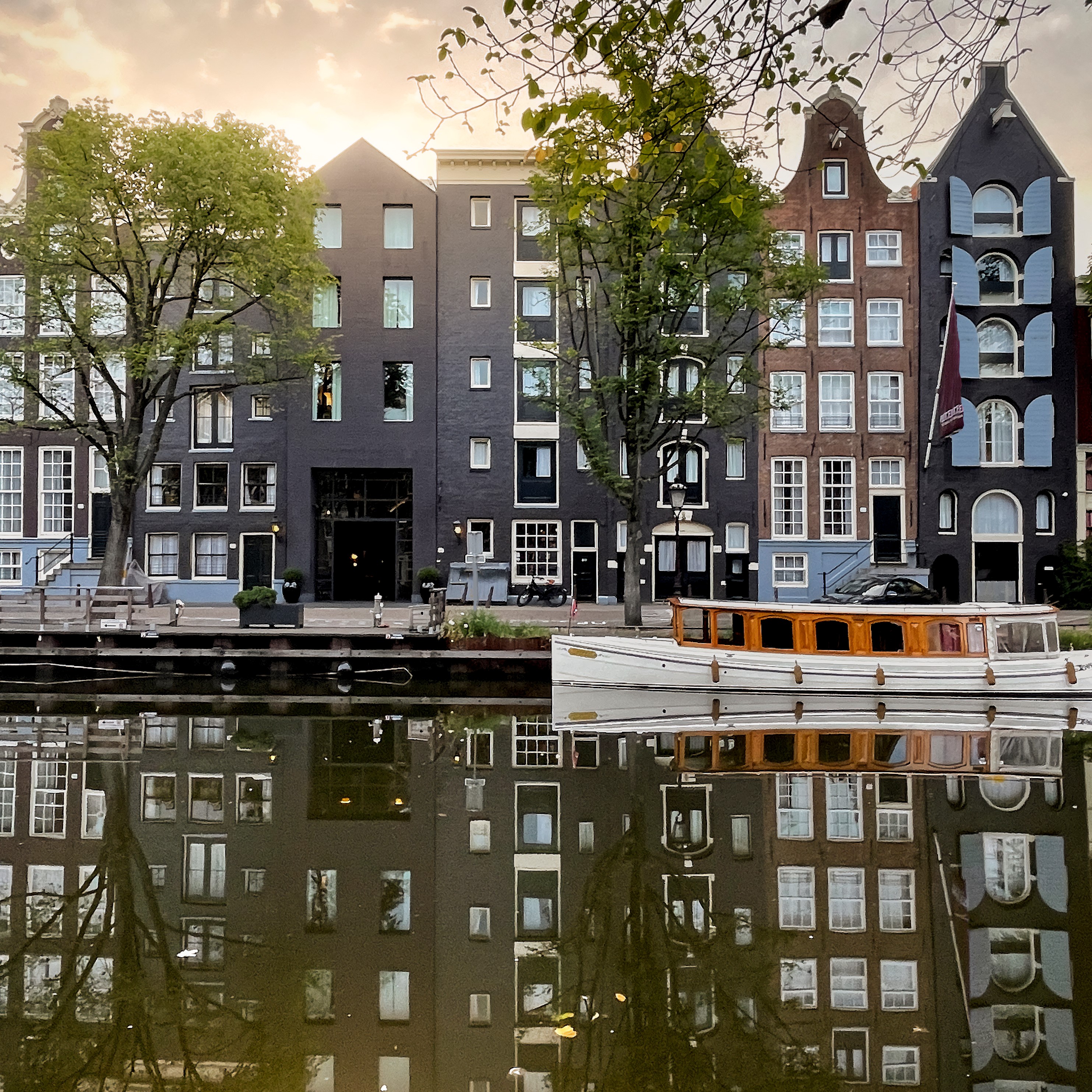 Scenic view of the Pulitzer Hotel in Amsterdam, with its historic facade reflecting in the calm waters of the canal.