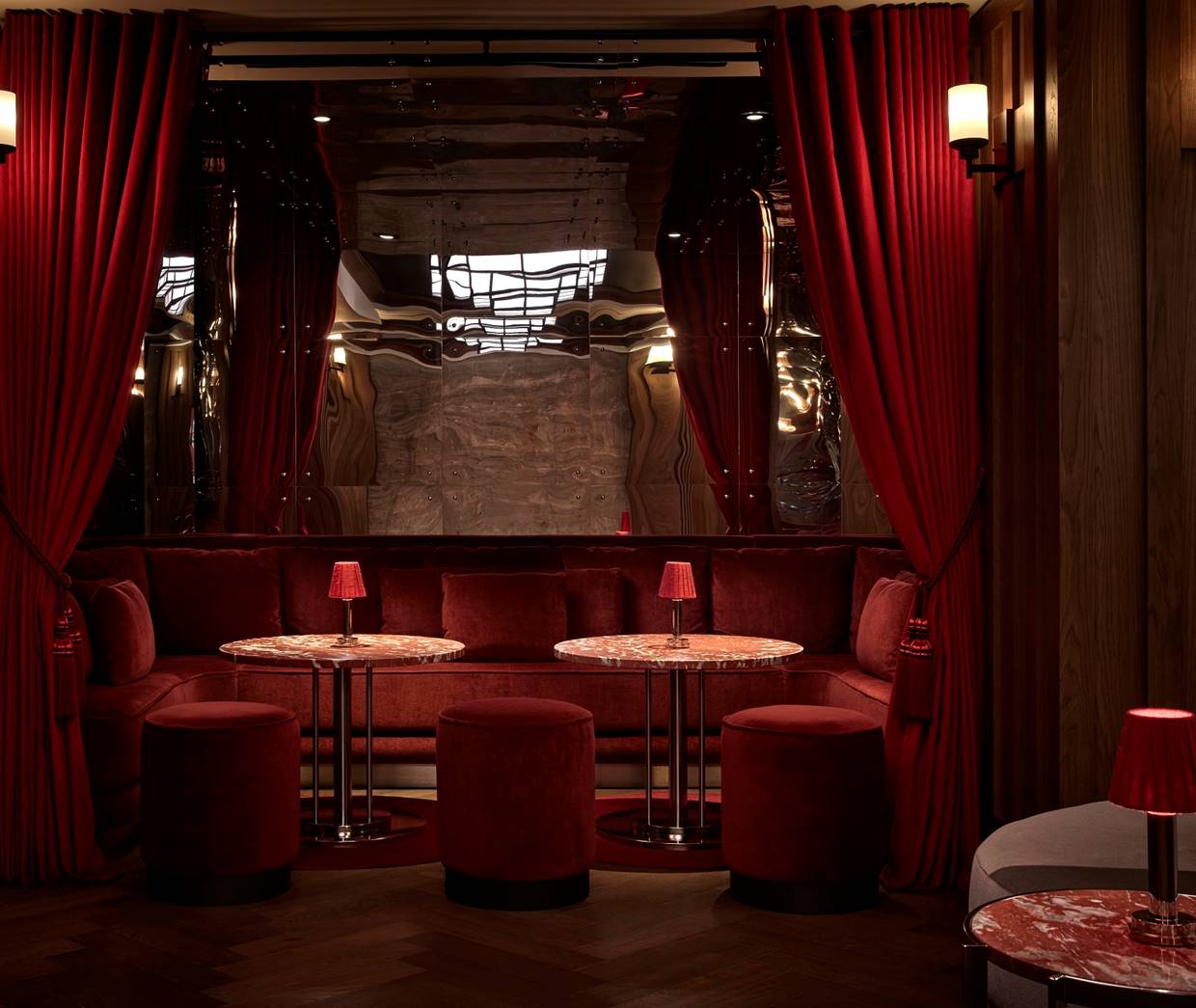 A trendy bar with a long marble counter, modern seating, and vibrant decor.