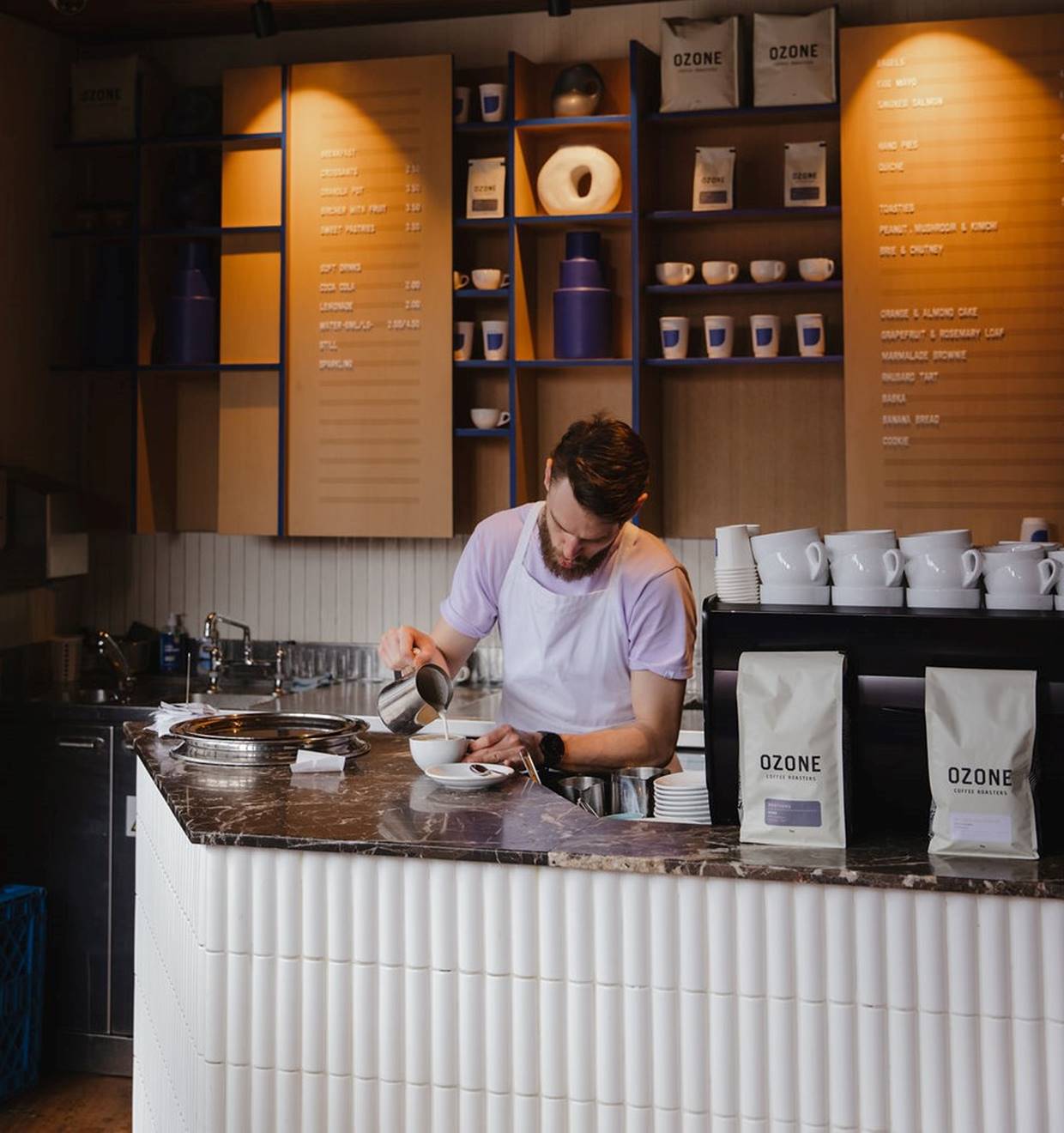 A man skillfully prepares coffee at a bustling coffee shop, showcasing his expertise and passion for brewing.