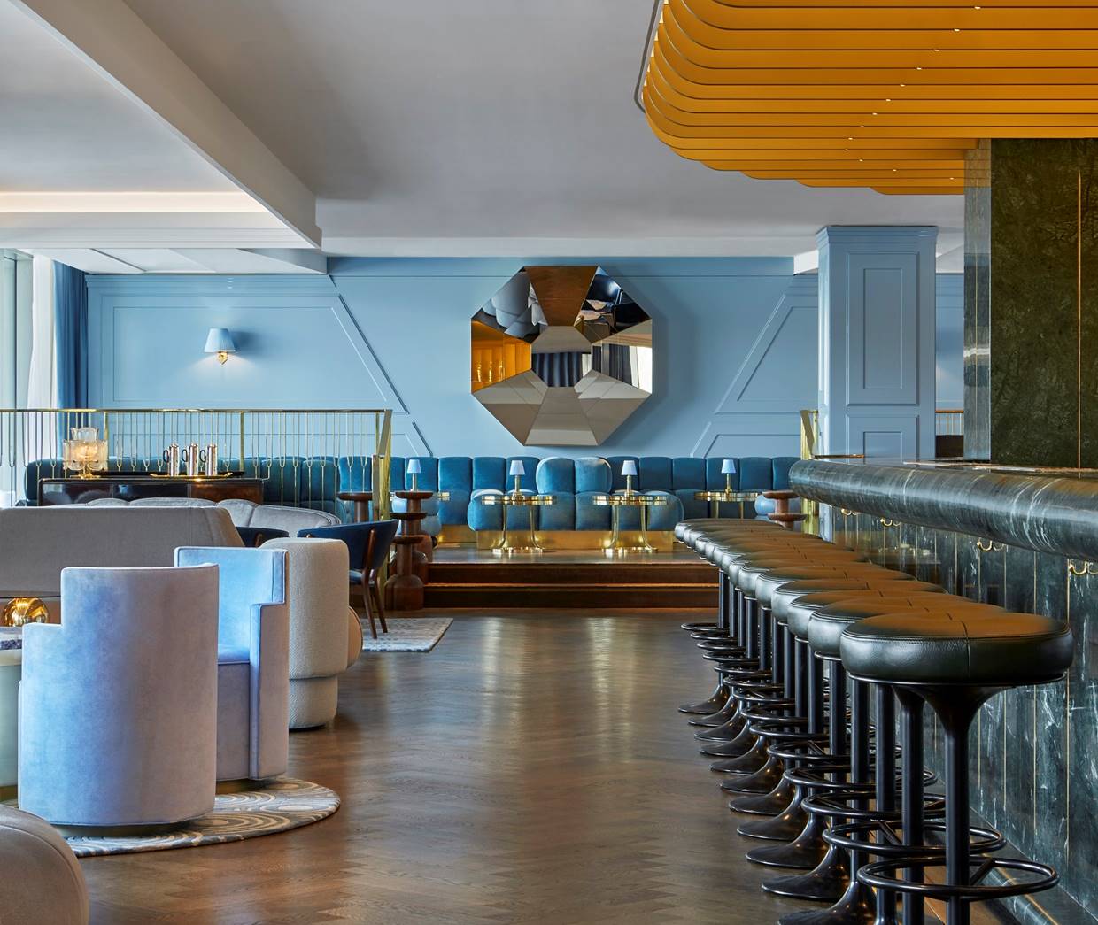 A trendy bar with a long marble counter, modern seating, and vibrant decor.