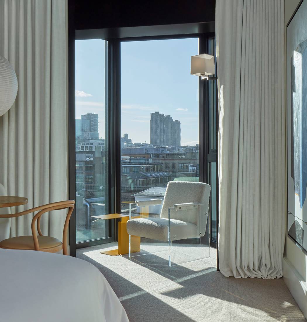 A spacious room with modern furnishings, large windows, and a serene, neutral color palette.