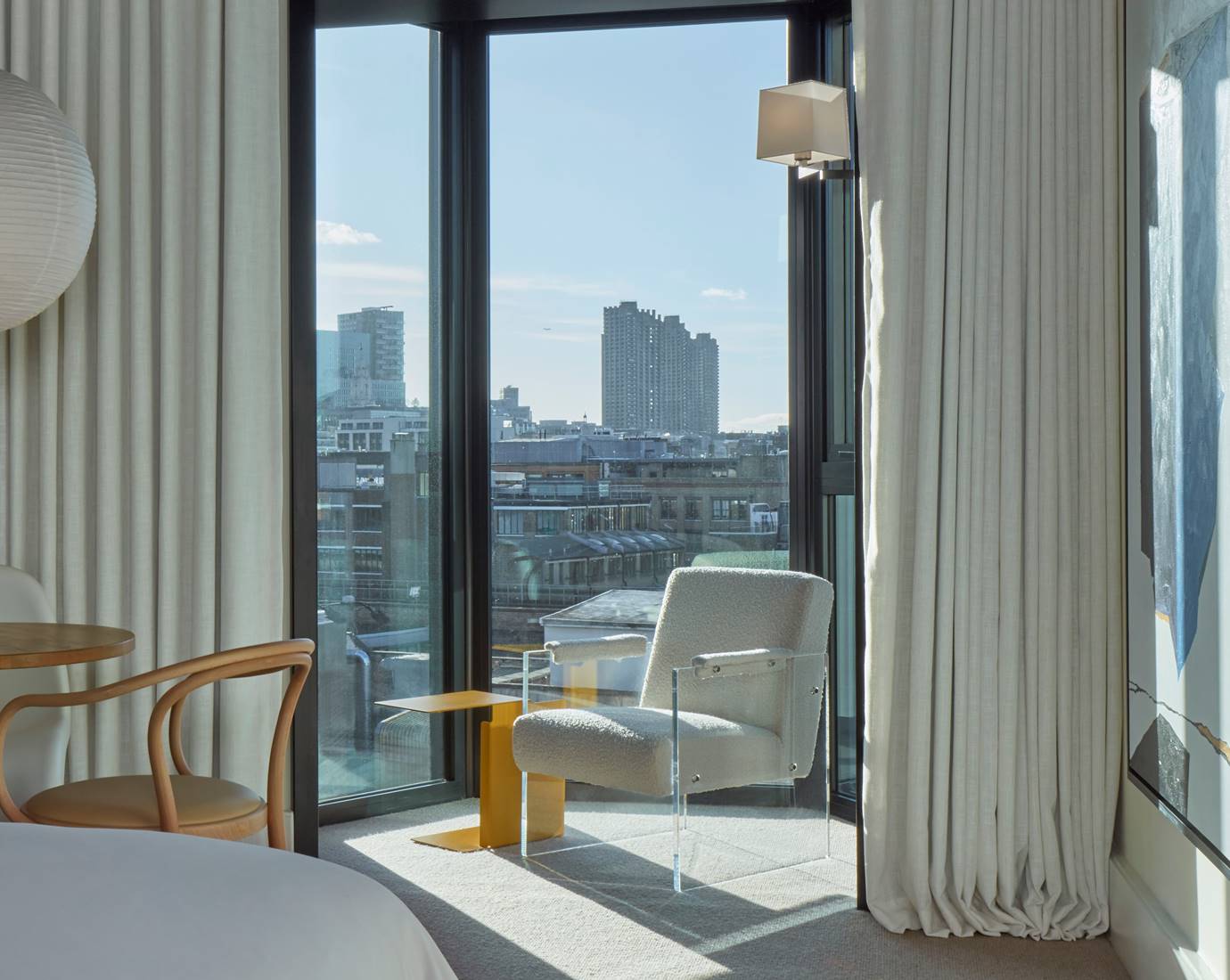 A spacious room with modern furnishings, large windows, and a serene, neutral color palette.