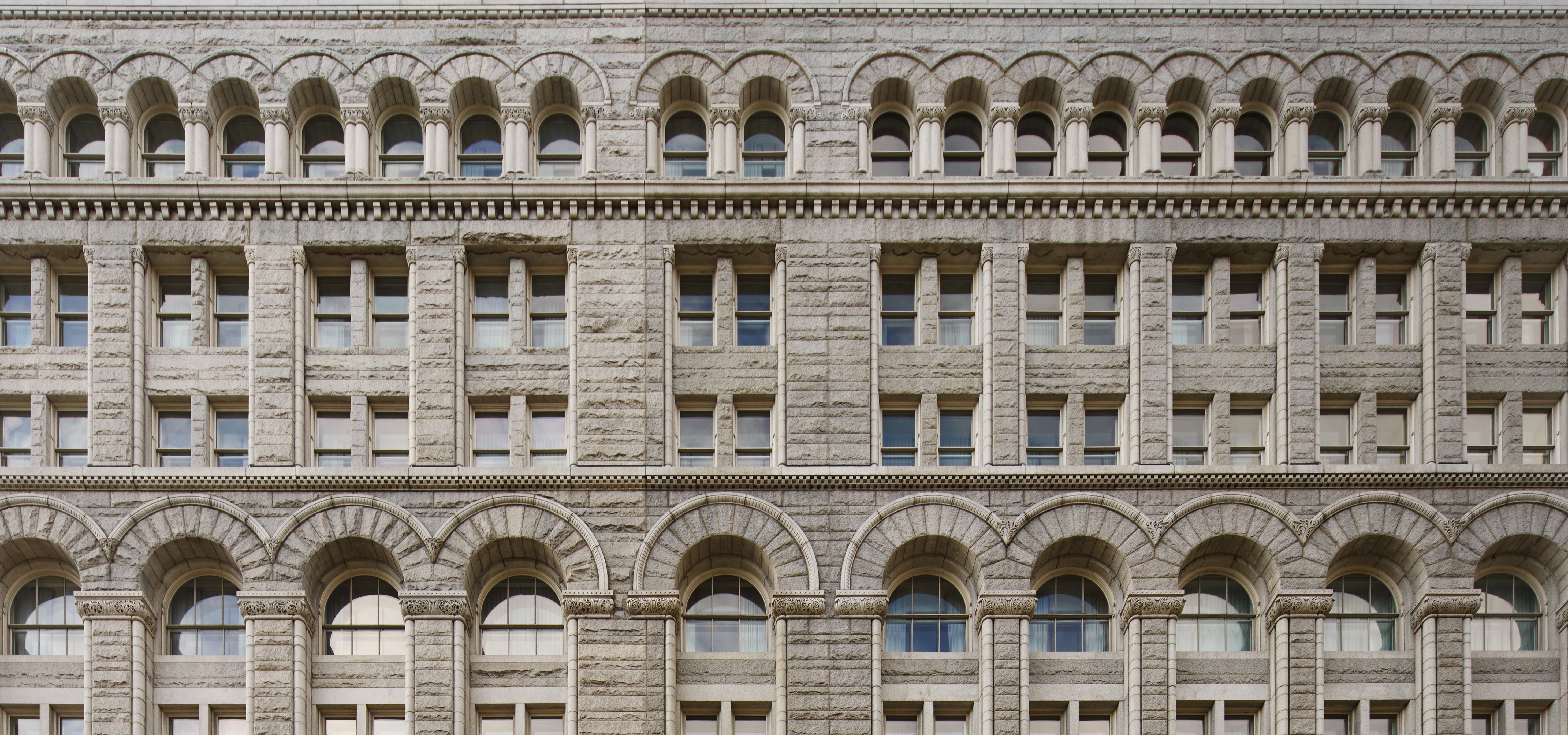 Close-up to the front view of Riggs DC hotel with classic architecture and beautiful small windows.