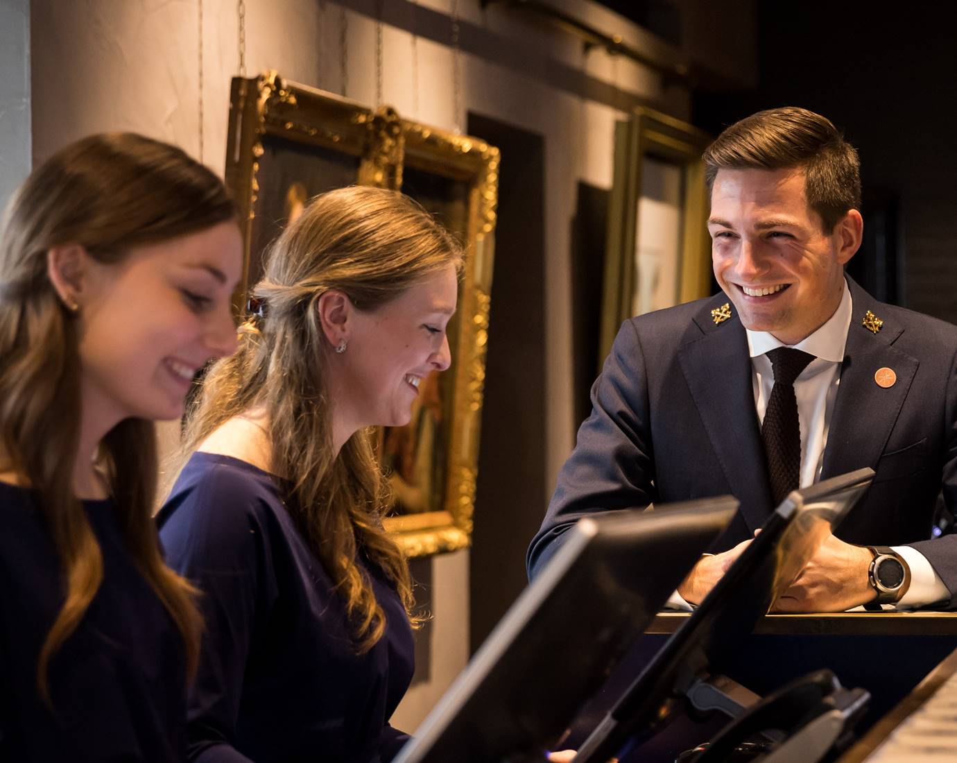 Recruitment photo shoot at Pulitzer Amsterdam, showcasing three staff members with warm smiles.
