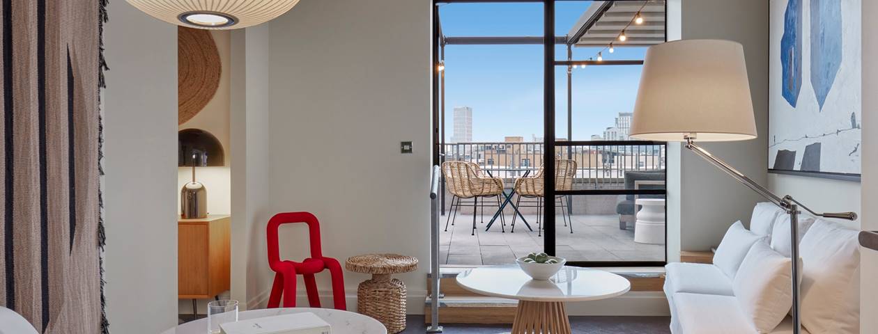 A modern living room featuring large windows that showcase a stunning view of the city skyline.