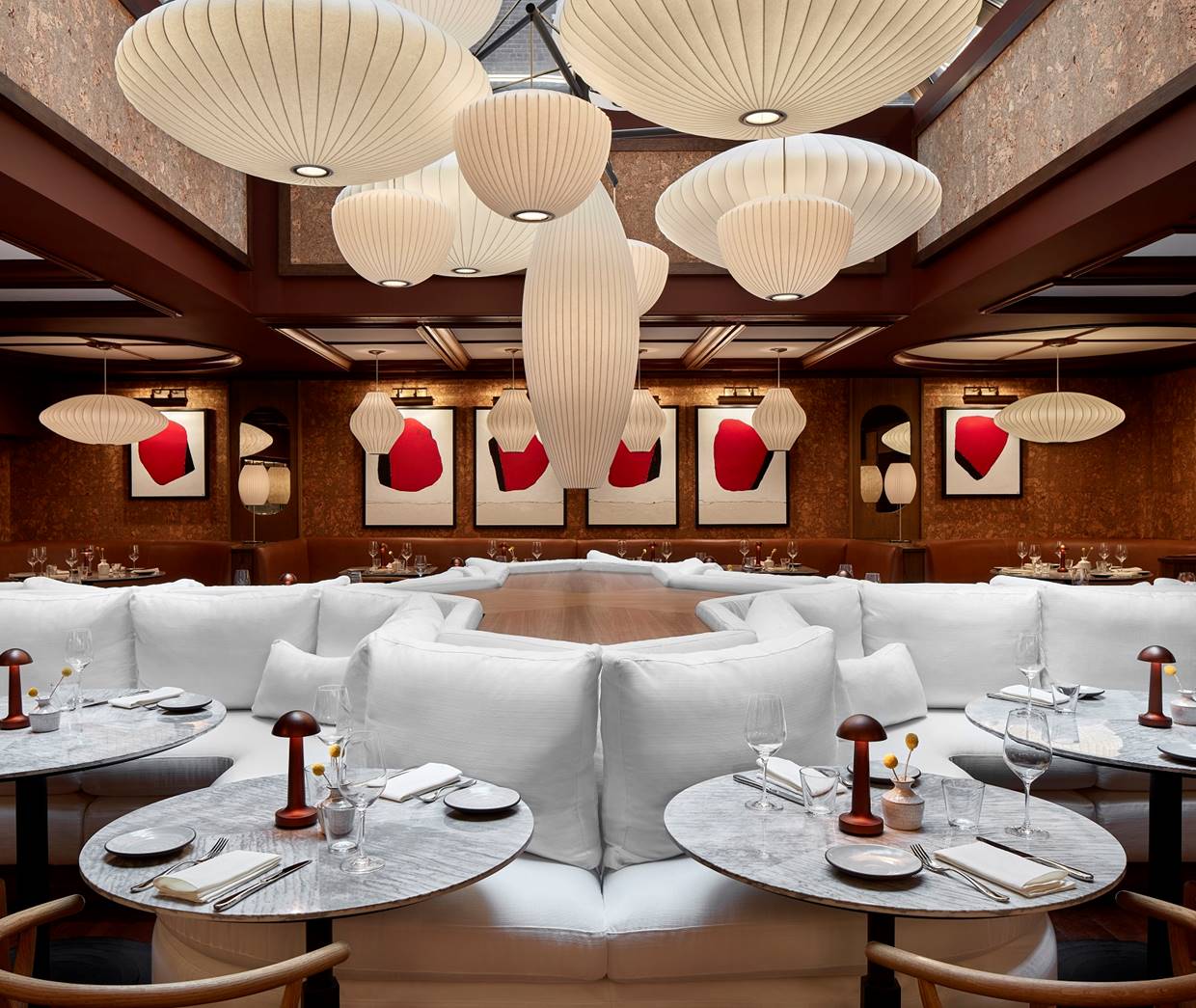 An upscale dining establishment showcasing white furniture and large, stylish lamps that enhance the ambiance.